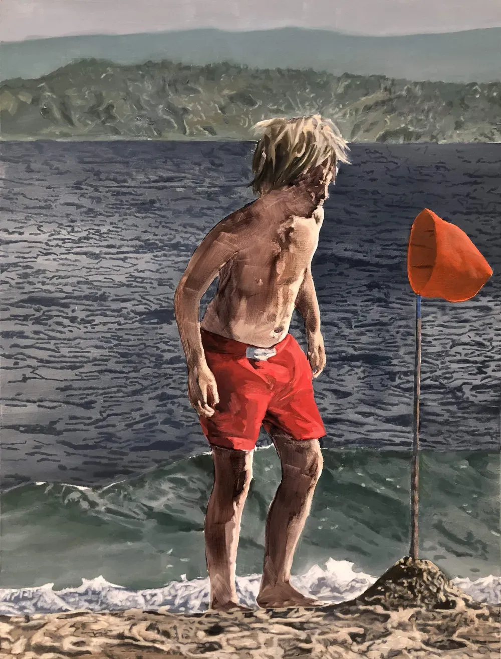 A boy enjoying the fascination of the seaside on a lovely day.