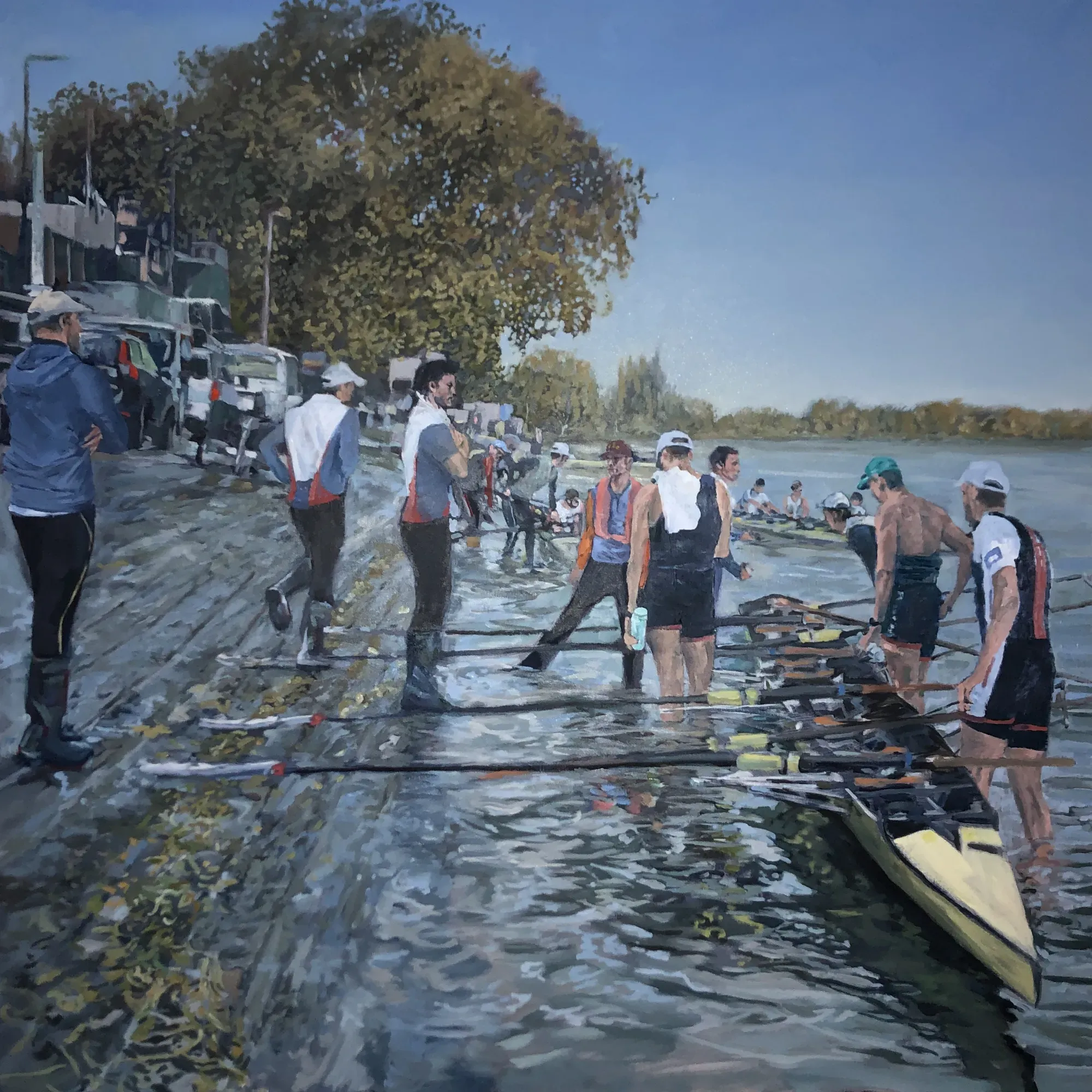 Rowers in bright kit readying their boats on Putney Embankment on a blue-grey morning.