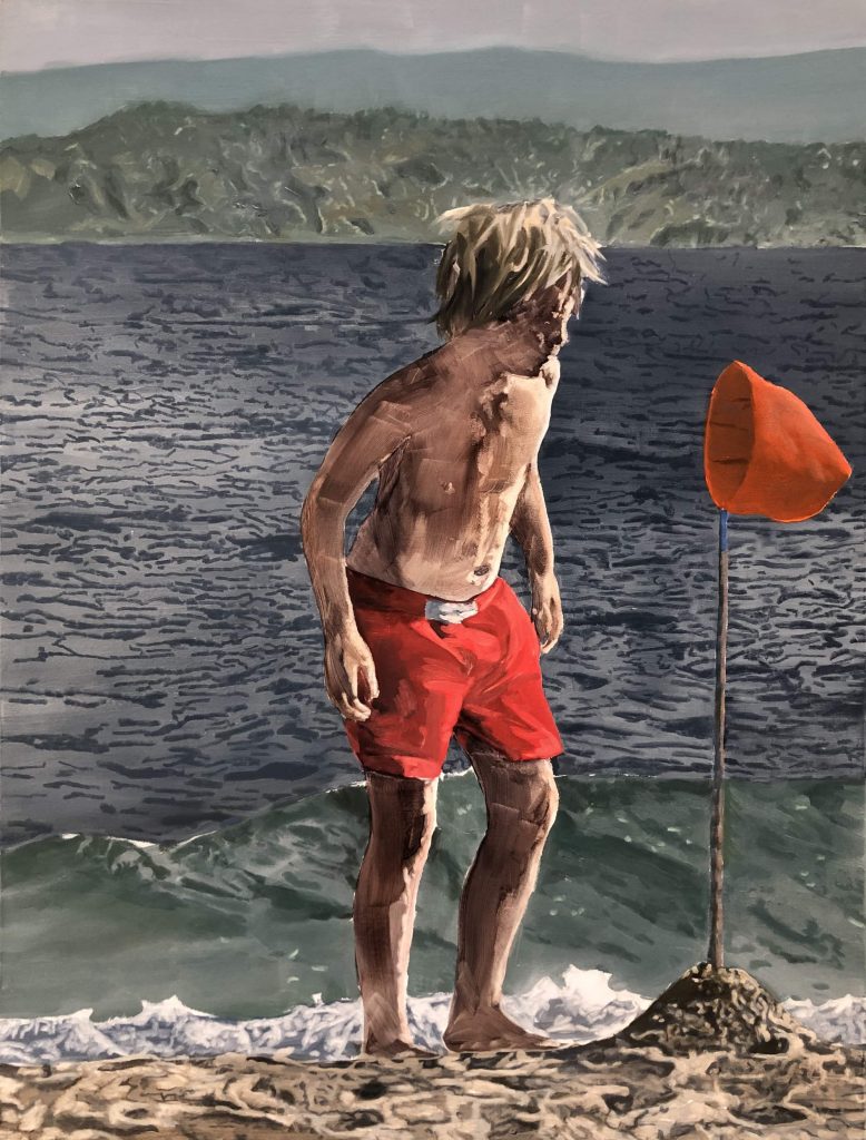 A boy enjoying the fascination of the seaside on a lovely day.