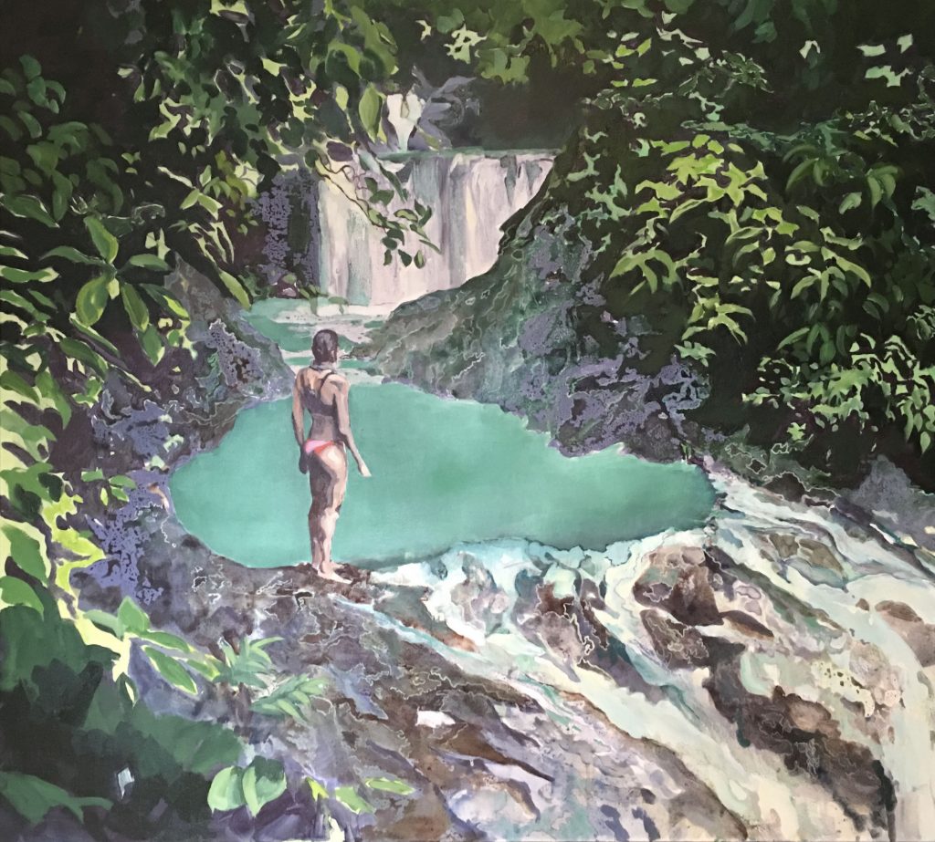 A female swimmer contemplates the beauty of her tropical rock-pool before entering the water.