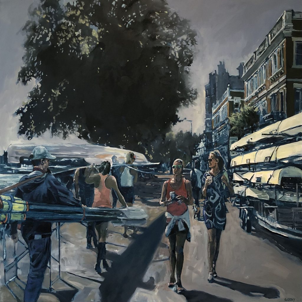 Two padestrians with coffee walking by rowers preapring to enter the water.